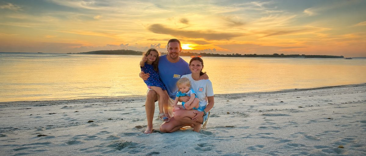 Anna und Oliver mit ihren beiden Kindern am Strand bei Sonnenuntergang