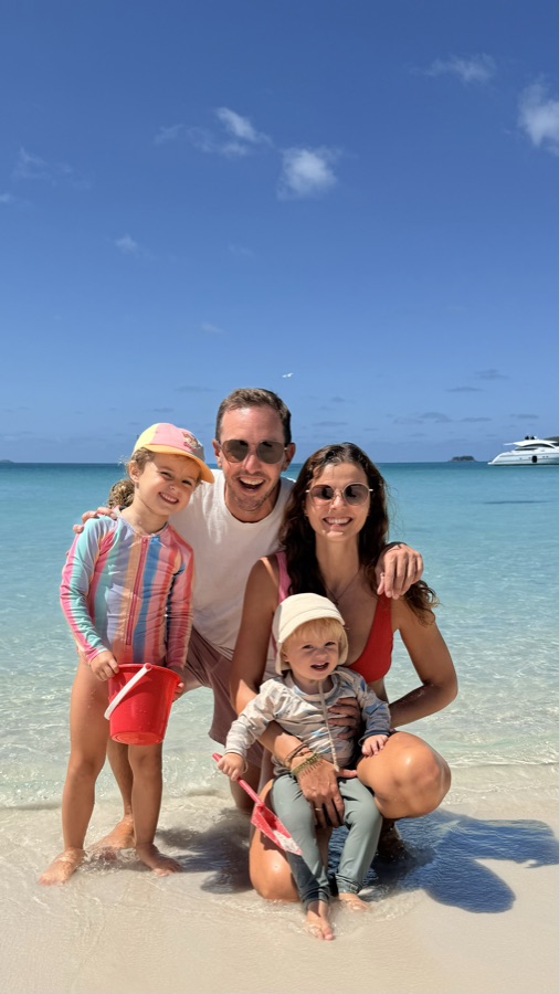 Familie im türkisblauen Wasser am Strand